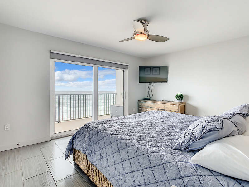 A bedroom with a tv and a beach view