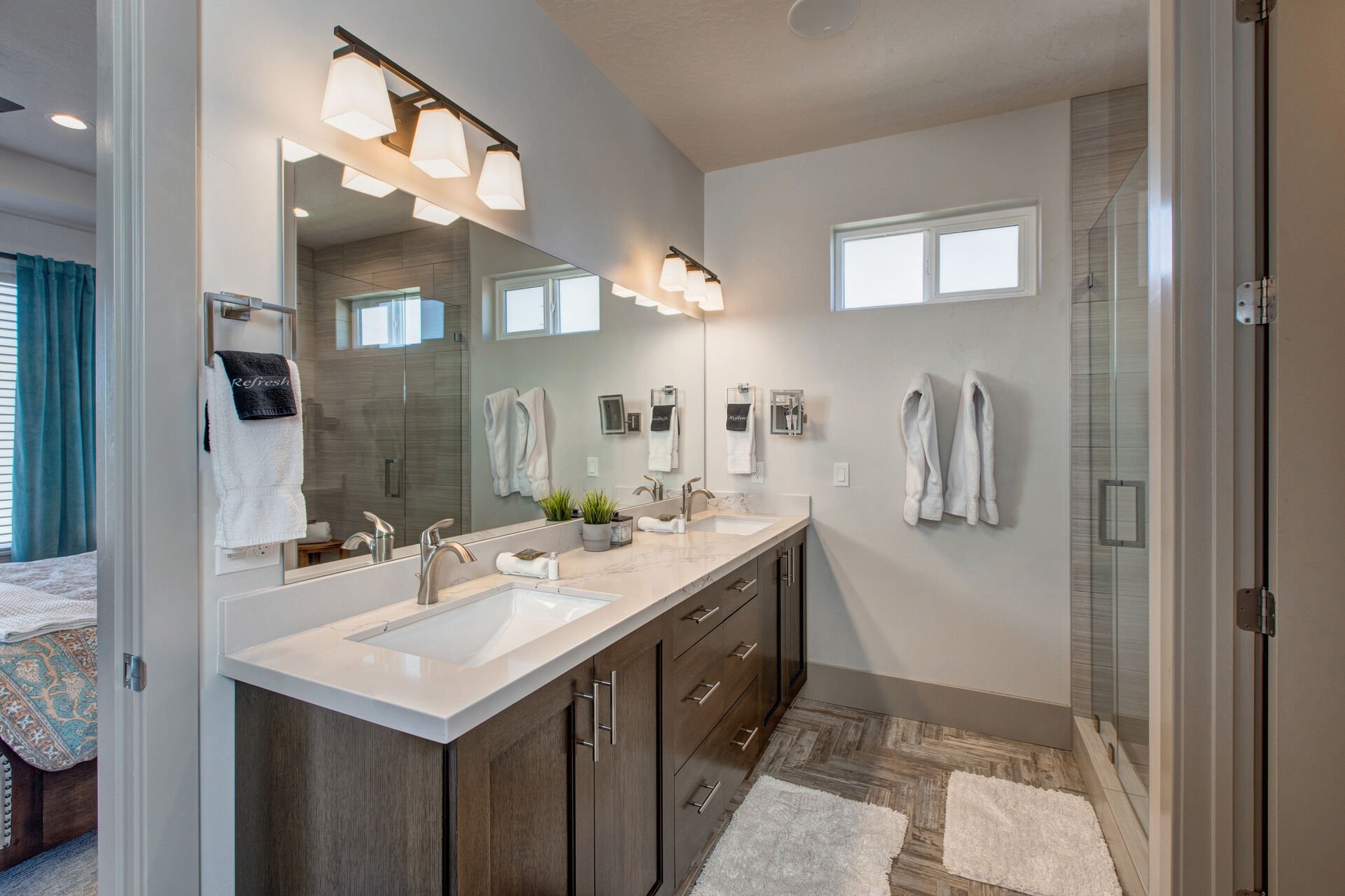 Master bathroom with double sinks, tub, shower, walk-in closet, and separate washroom