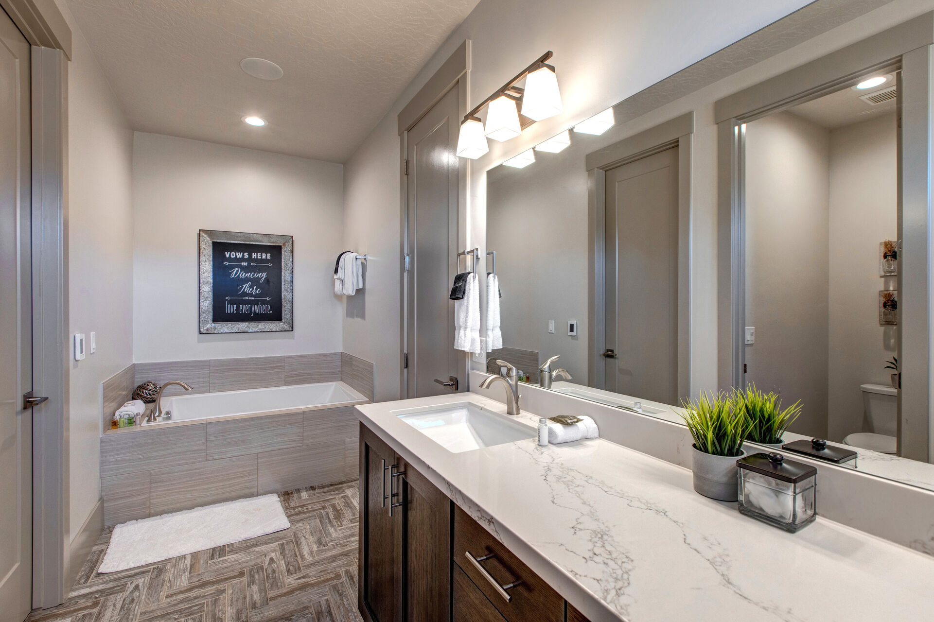 Master Bathroom with double sinks, large soaking tub, over-sized shower with seating, walk-in closet, and separate washroom