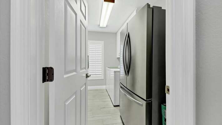 Laundry room with full size washer and dryer and additional fridge