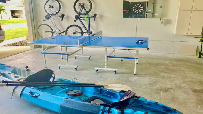 Garage with ping-pong table, two bikes and a two-seater fishing kayak