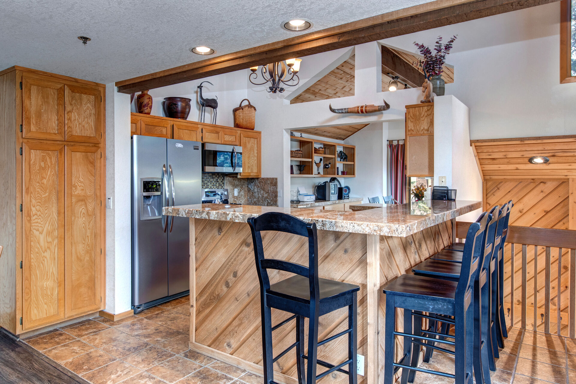 Fully Equipped Kitchen with stainless steel Frigidaire appliances, stone countertops, breakfast nook with seating for four, and bar seating for four