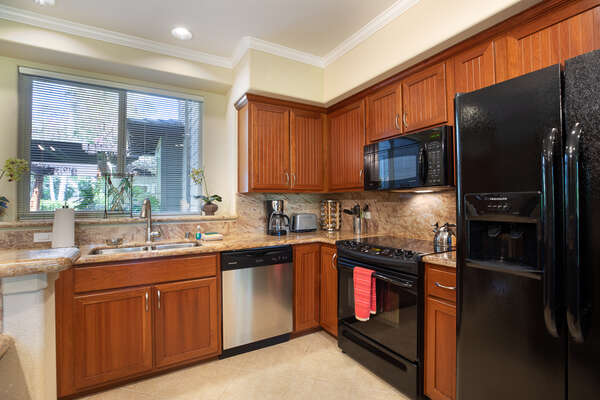 Fully Equipped Kitchen with Granite Counter Tops and Black Appliances