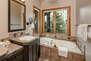 Master Bathroom with dual vanities, large tiled shower, jetted tub, and separate wash-closet