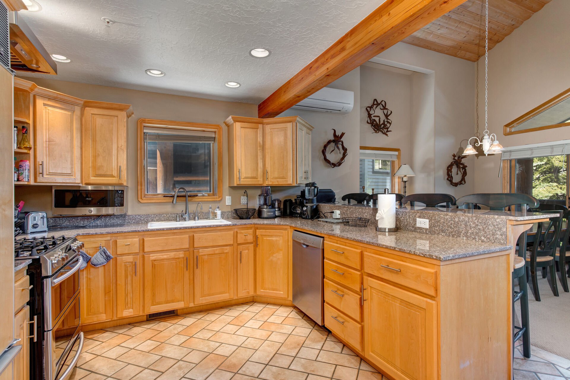 Fully Equipped Kitchen with stainless steel LG appliances, and bar seating for four