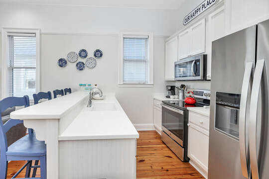 The galley-style Kitchen has stainless steel appliances and bright, white countertops.