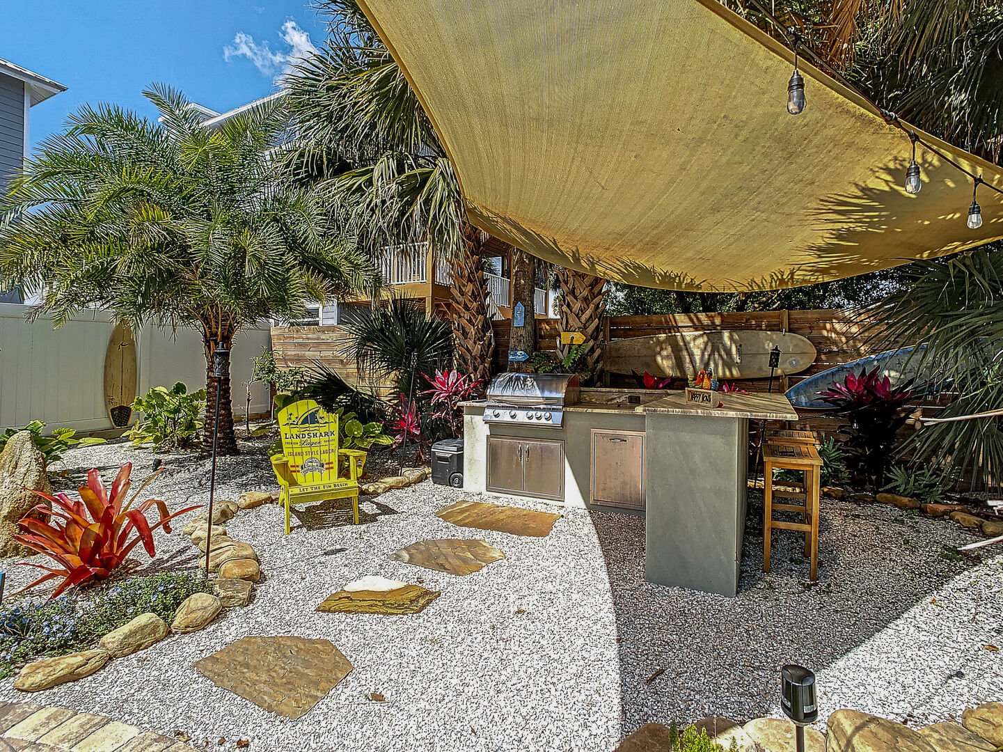A backyard with a seating area, bar and gas bar-b-que grill.