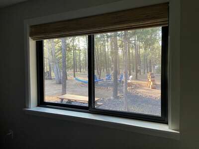 The main bedroom window looks out to the wooded backyard and many of its amenities.