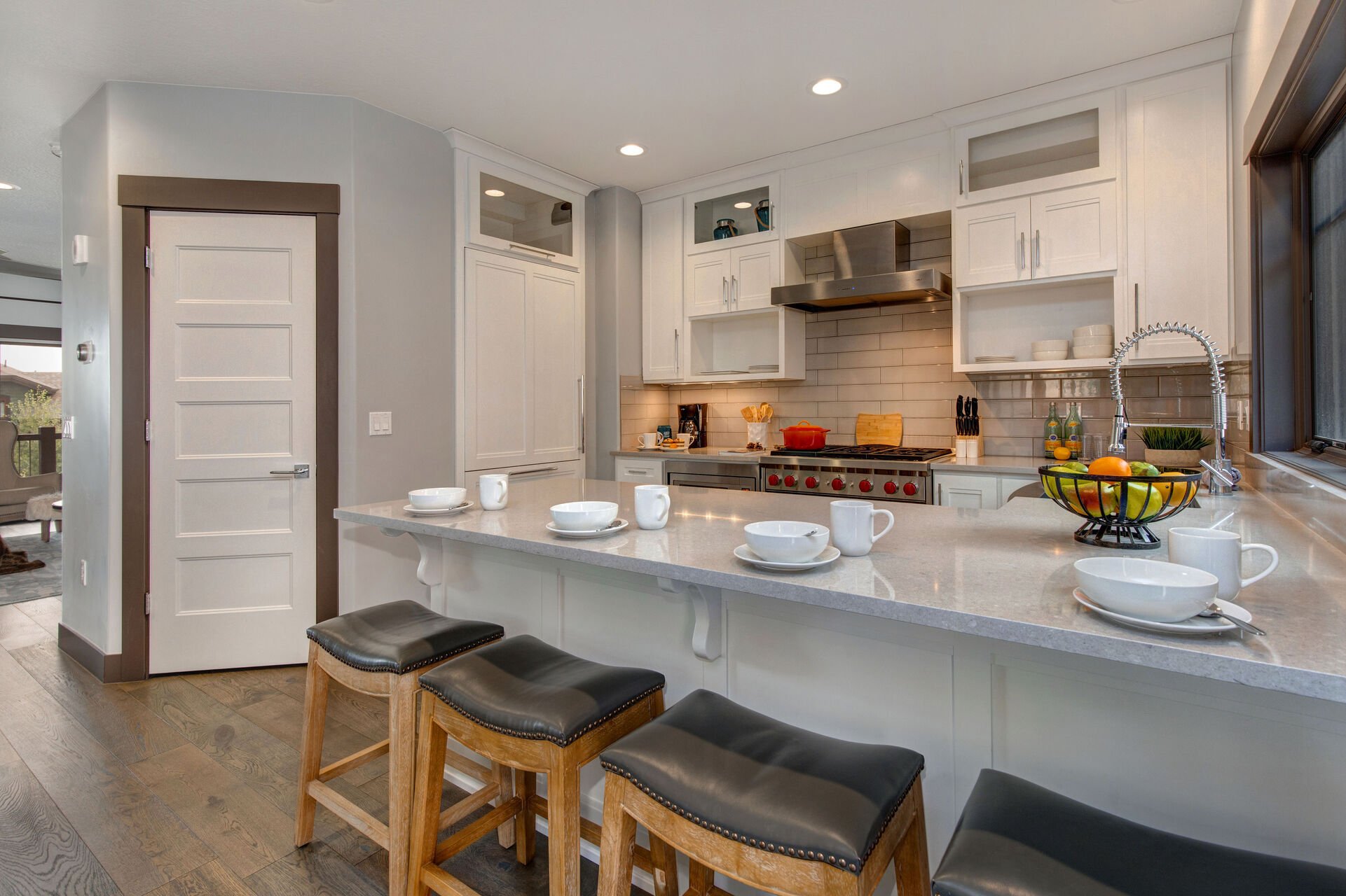 Fully Equipped Kitchen with stunning stone countertops, stainless steel Wolf appliances, SubZero fridge, and bar seating for four