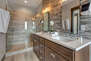Master Bathroom with dual vanities, oversized tiled shower, private washroom, and jetted tub