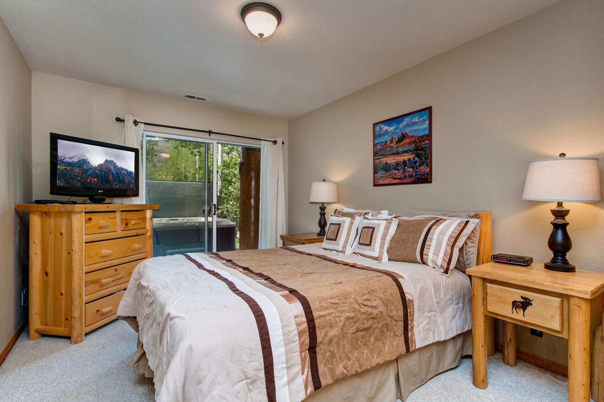 Lower Level Master Bedroom with queen bed, LG smart tv, private hot tub patio access, and en suite bathroom