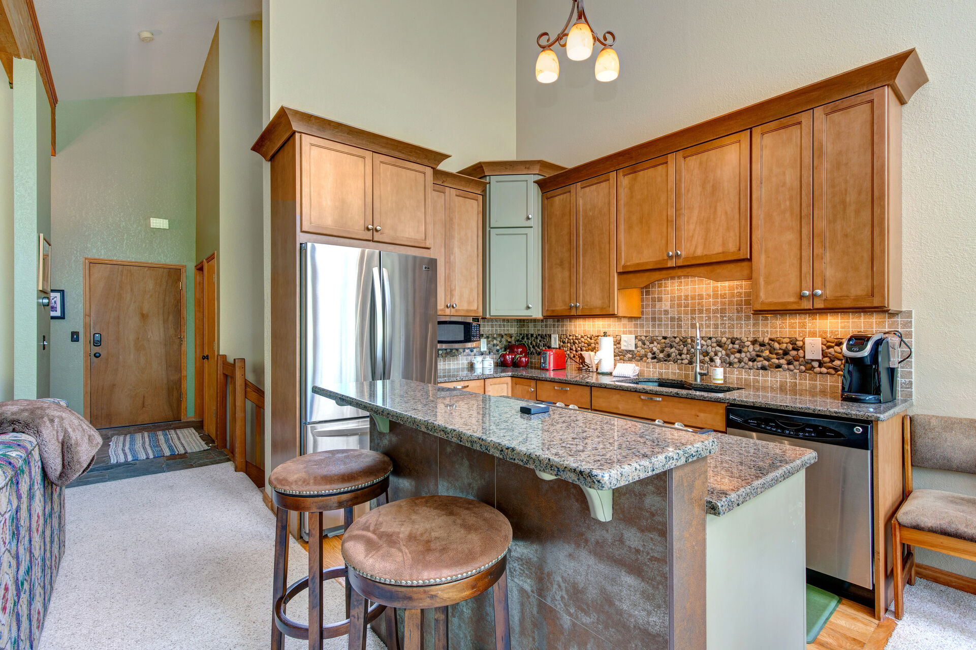 Fully Equipped Kitchen with stone countertops, separate cooking island, stainless steel appliances, and bar seating for two