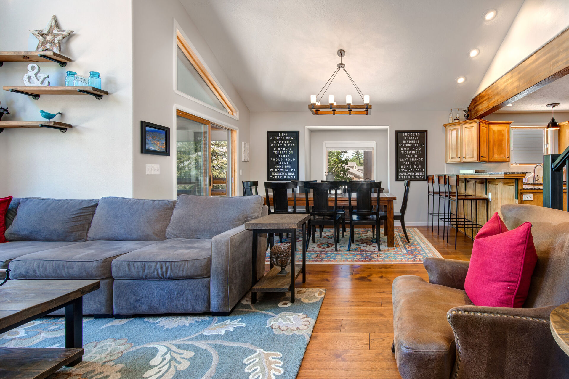 Living Room with Samsung smart tv, plush sectional sofa, gas fireplace, floor to ceiling windows, and separate sitting area with two leather armchairs