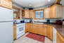 Fully Equipped Kitchen with vast counter-space, stone countertops, Whirlpool appliances, and bar seating for three