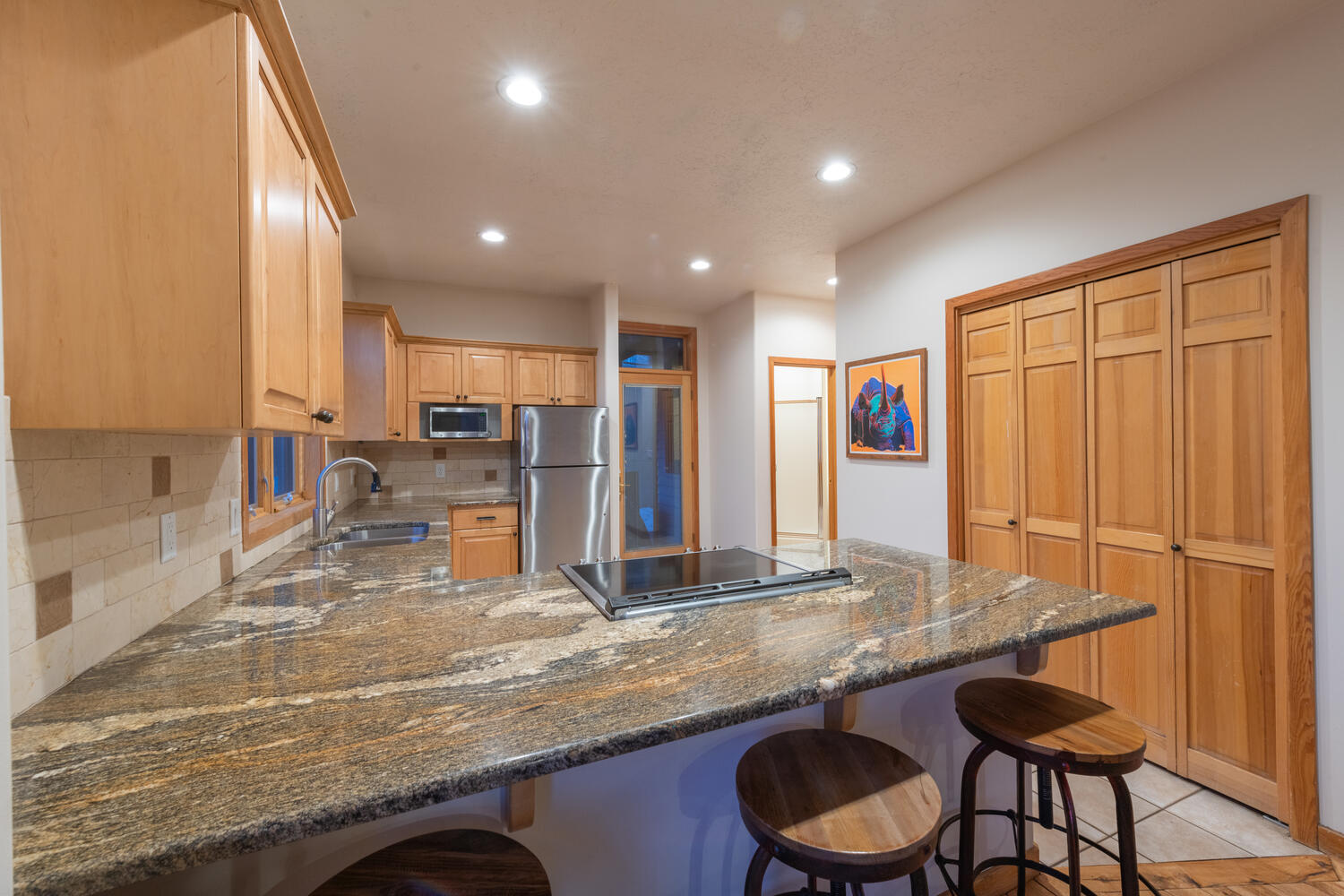 Fully Equipped Kitchen with Stone Counters and Bar Seating