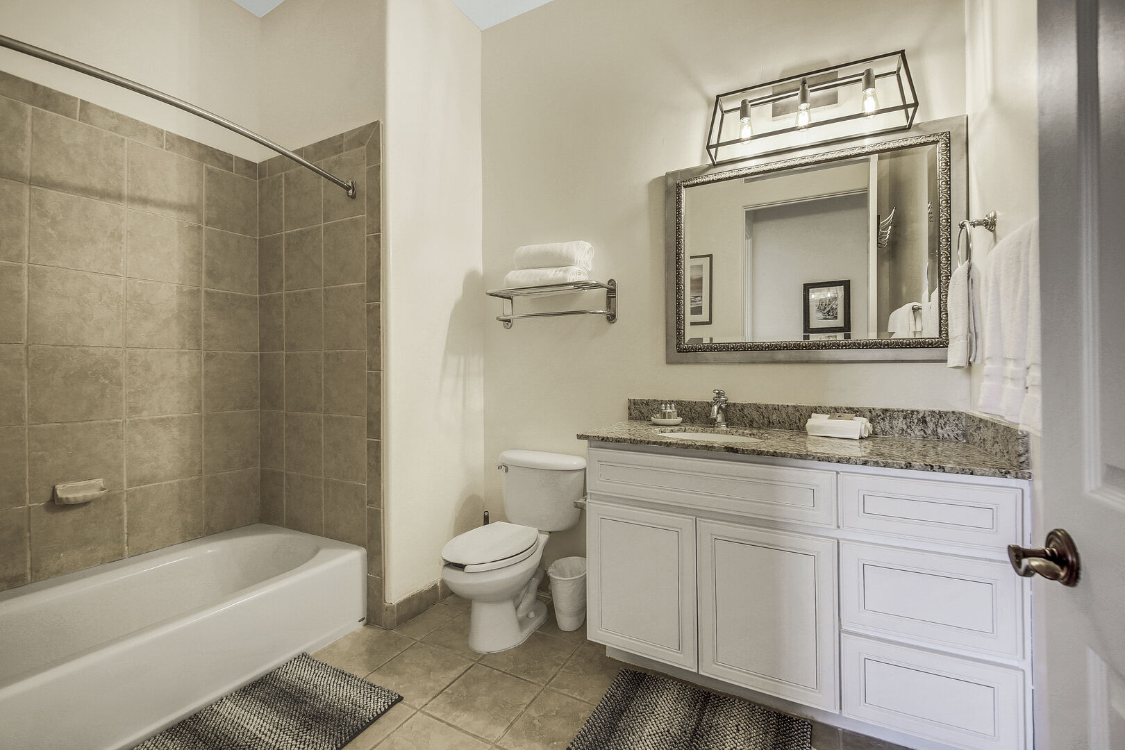 The hallway bathroom is located just outside of the Master Suite and features a shower and tub combo, and a vanity sink.