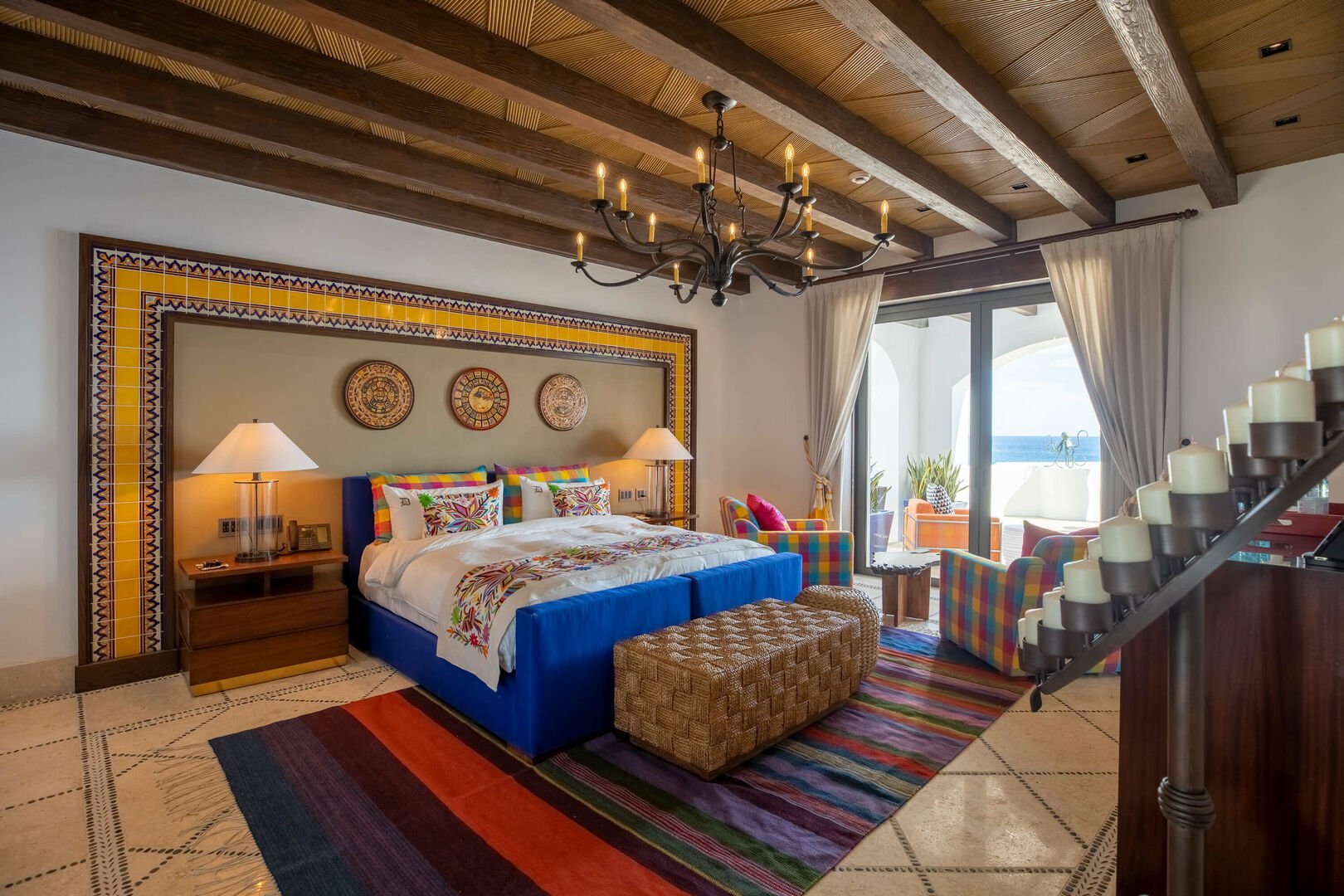 Bedroom of La Datcha, with a large queen bed and a sliding glass door leading to a beach facing patio.
