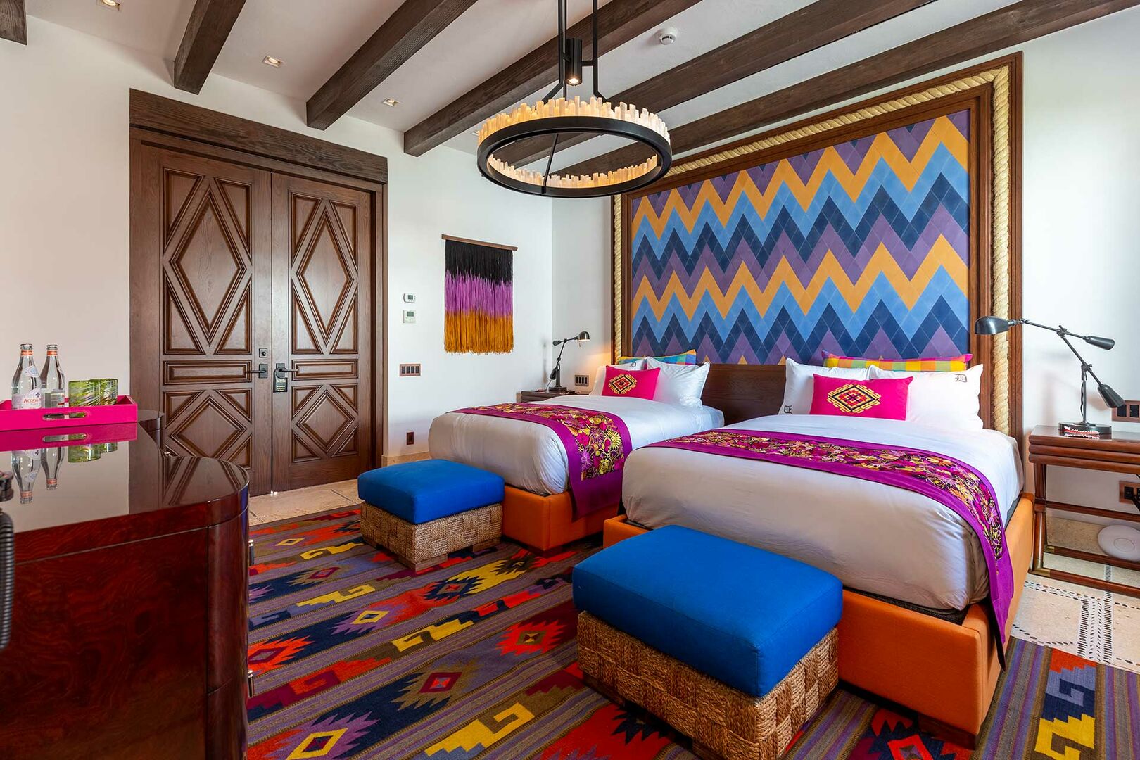 Two beds sit side by side in a bedroom of La Datcha, with colorful bedframes.