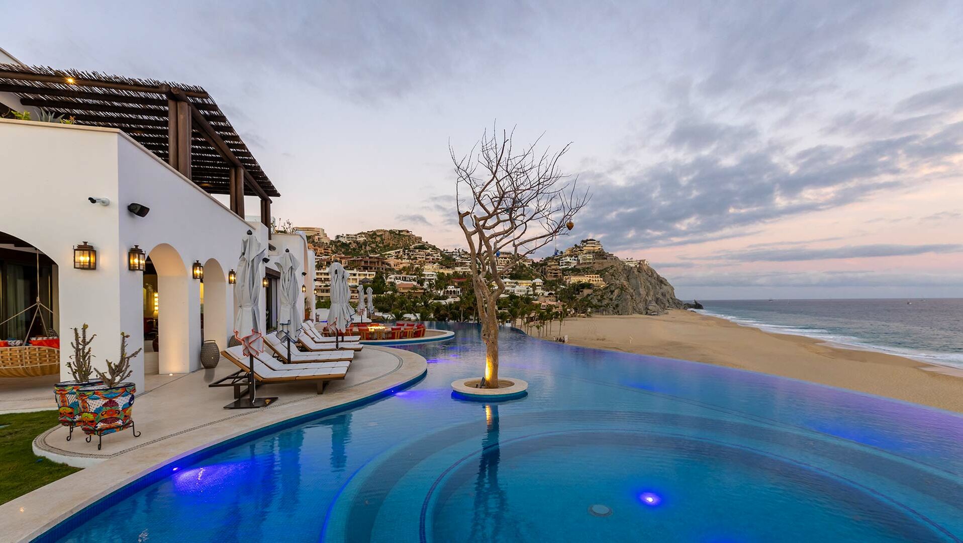 A tree sits in the middle of the pool of this Los Cabos beachfront villa.