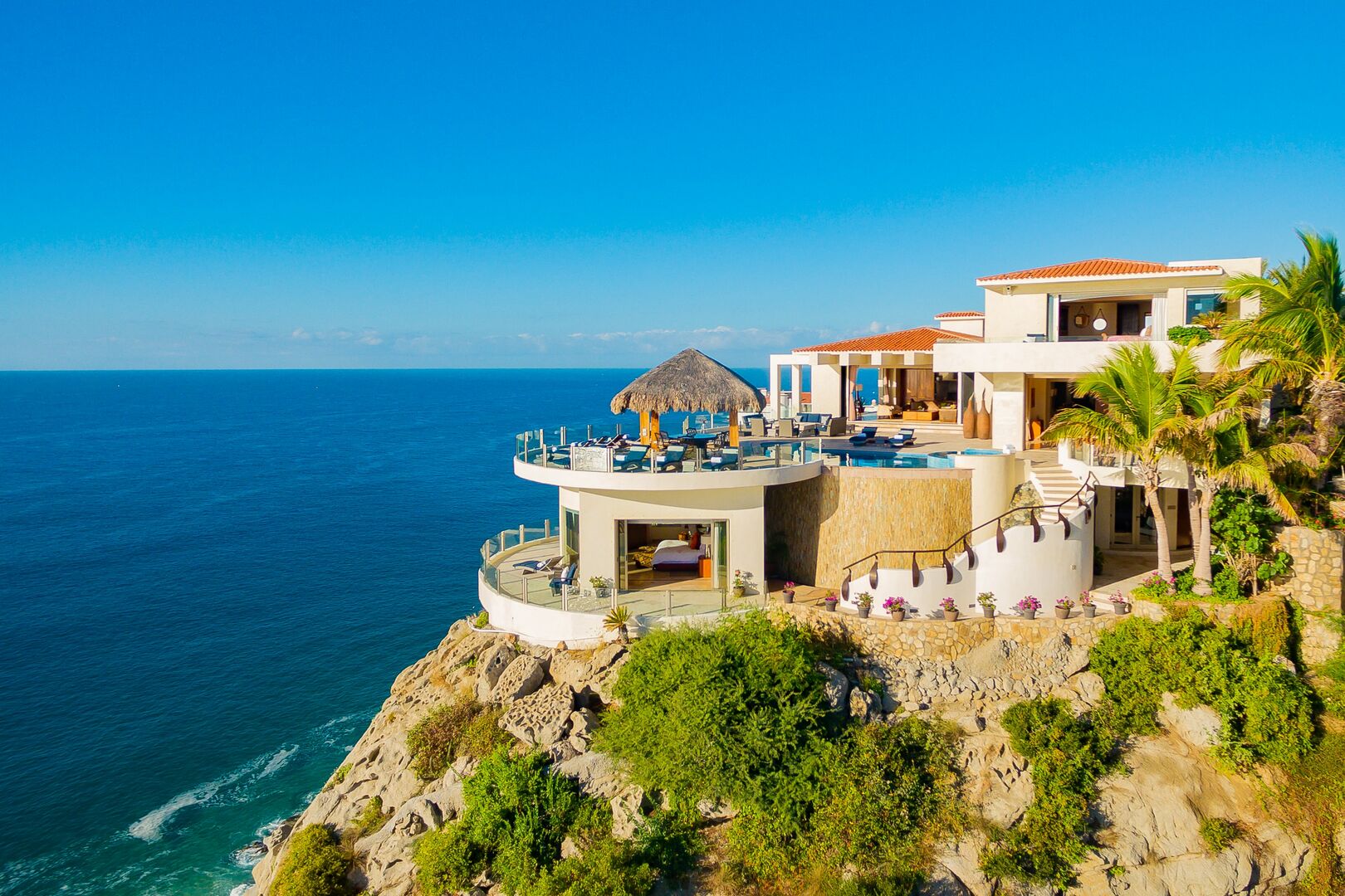 A sideview of this oceanfront home in Los Cabos that shows a side staircase and one car garage.