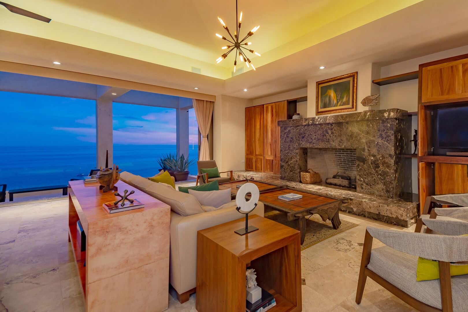 A seating are in this oceanfront home in Los Cabos next to a large fireplace.