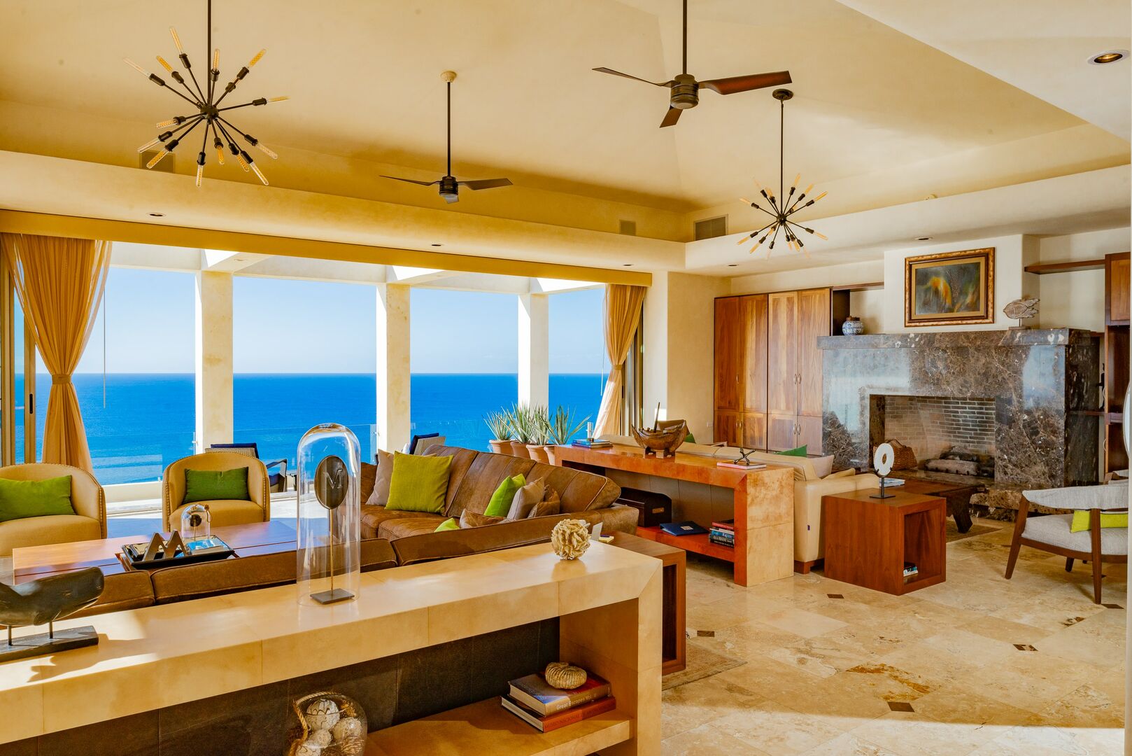 The living room and fireplace with a view of the ocean through the windows.