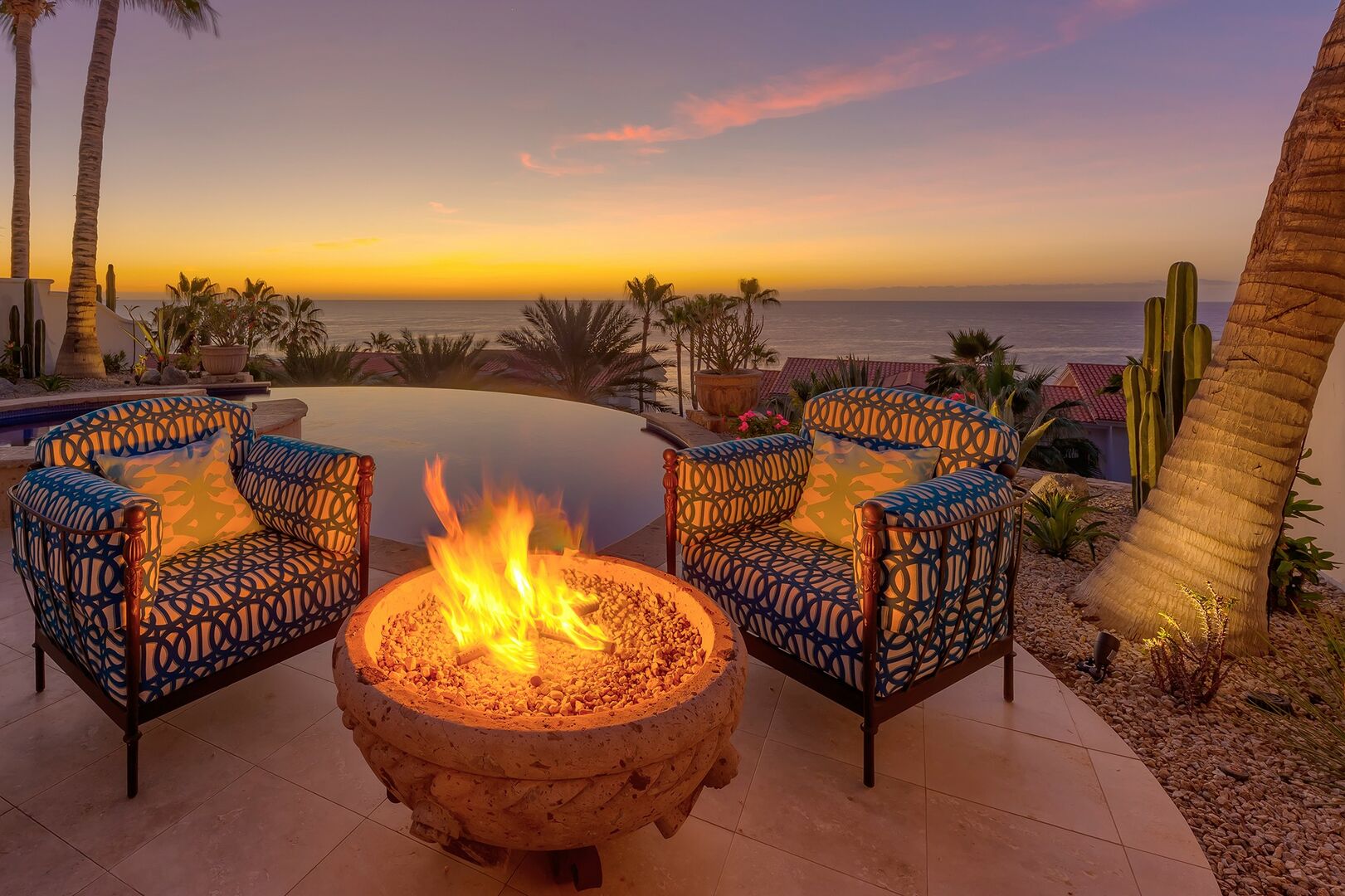 An outdoor fireplace with an ocean view at Villa Pura Vida.