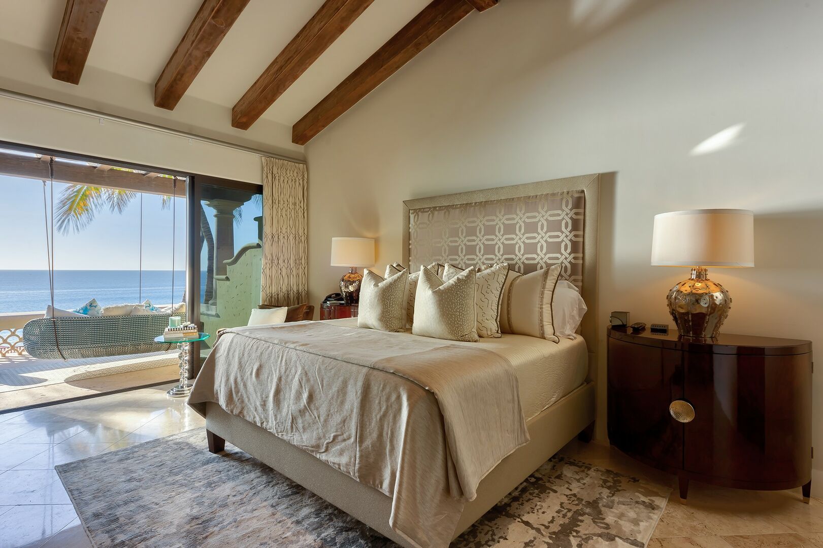Exposed wood beams on the ceiling of bedroom number 2 with a view of the ocean from the balcony.