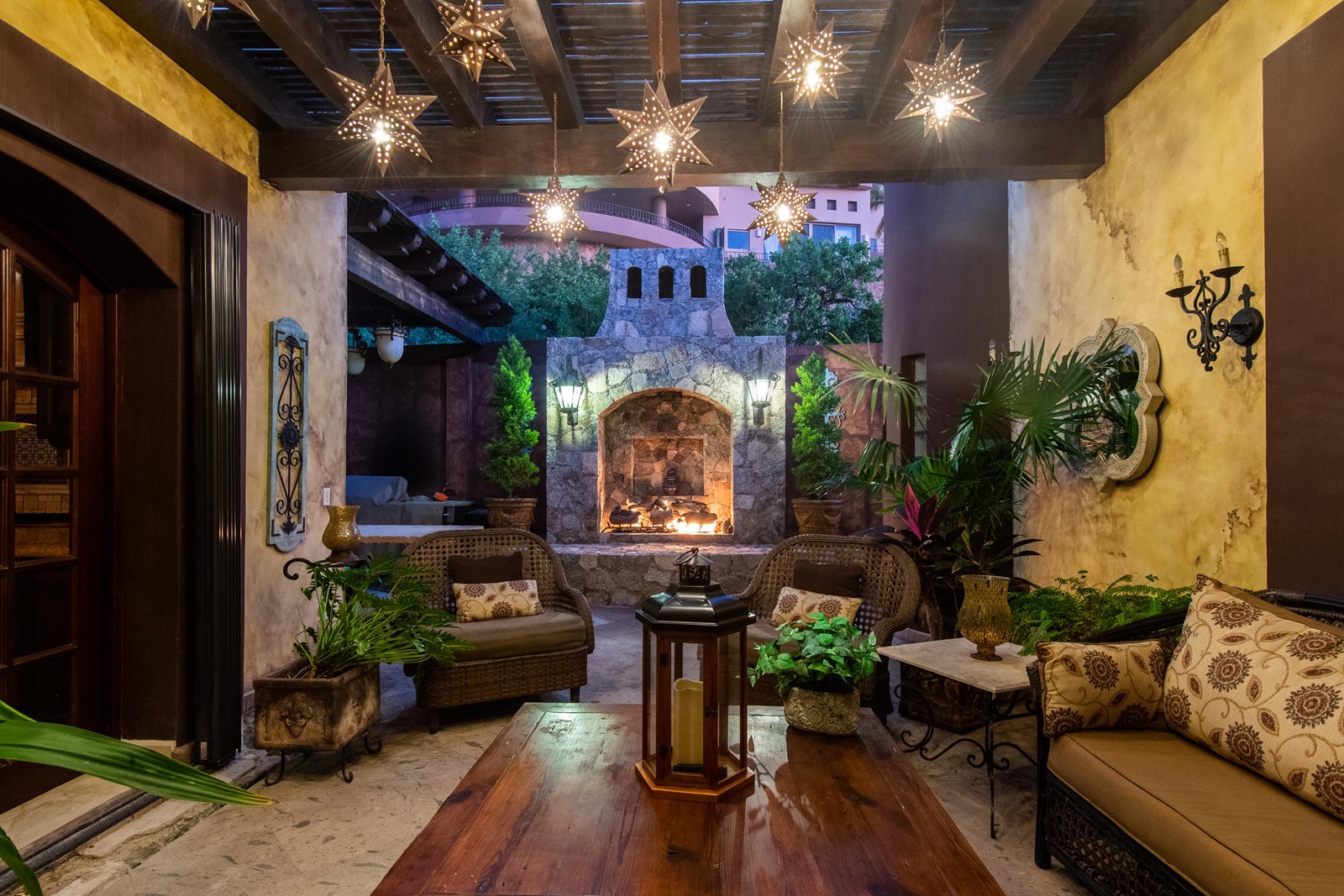 A breezeway leading to an outside fireplace and seating area in the villa.