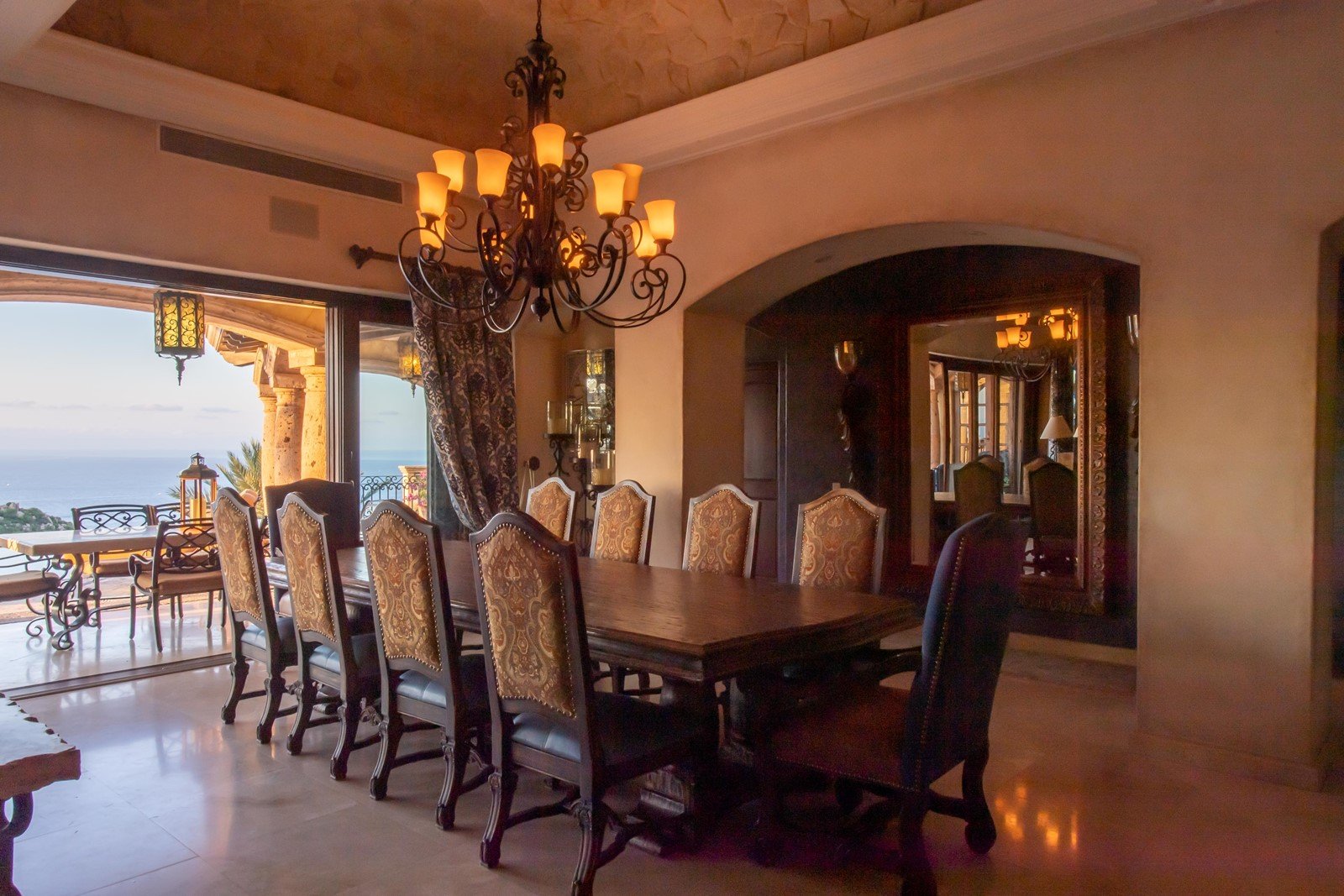 A view of the dining table with the outside door open to view the ocean from the table.