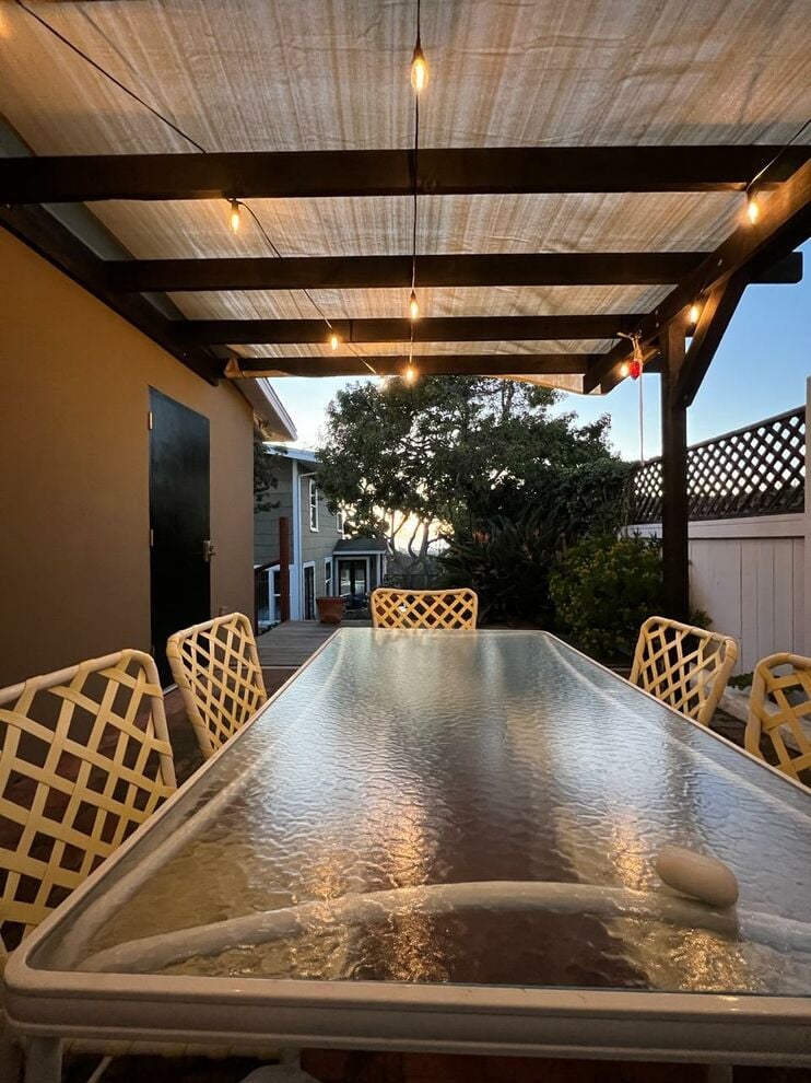 Raised patio with lighted covered trellis and Brown Jordan dining table for 6