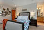 Master Bedroom with queen bed, leather arm chair, and en suite bathroom