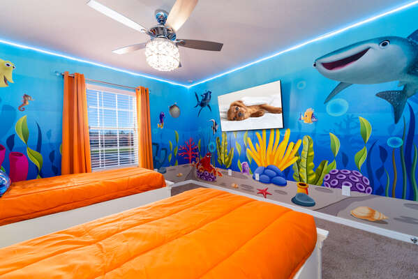 Undersea themed children's room has twin beds and wall mounted flatscreen TV