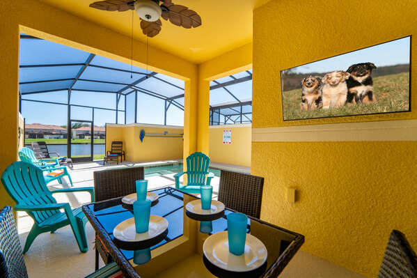 Shaded lanai has a wall mounted flatscreen TV and patio table for enjoying meals outdoors