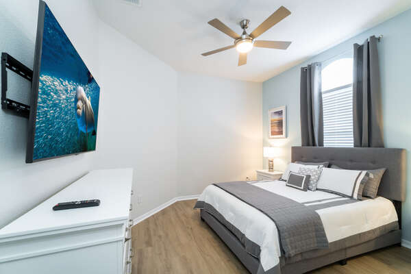 bedroom 2 with queen bed, remote operated ceiling fan and 50