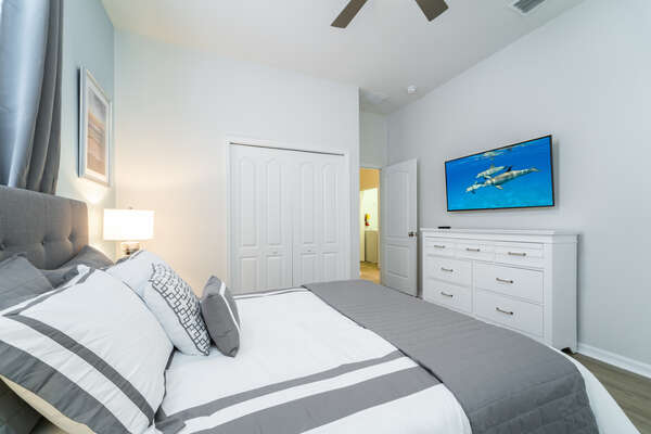 bedroom 2 with queen bed, remote operated ceiling fan and 50