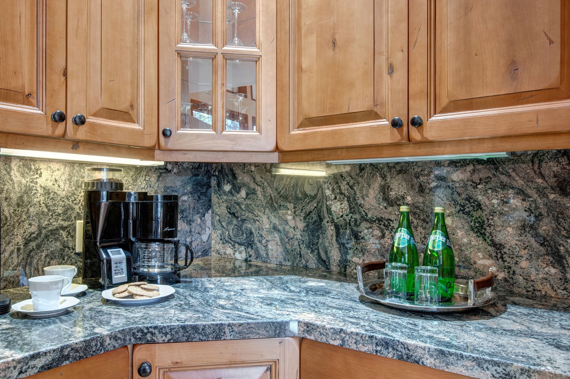 Fully Equipped gourmet kitchen with gorgeous stone countertops and backsplash, stainless steel appliances, wine fridge, double ovens, full sized laundry units, and island bar seating for 3