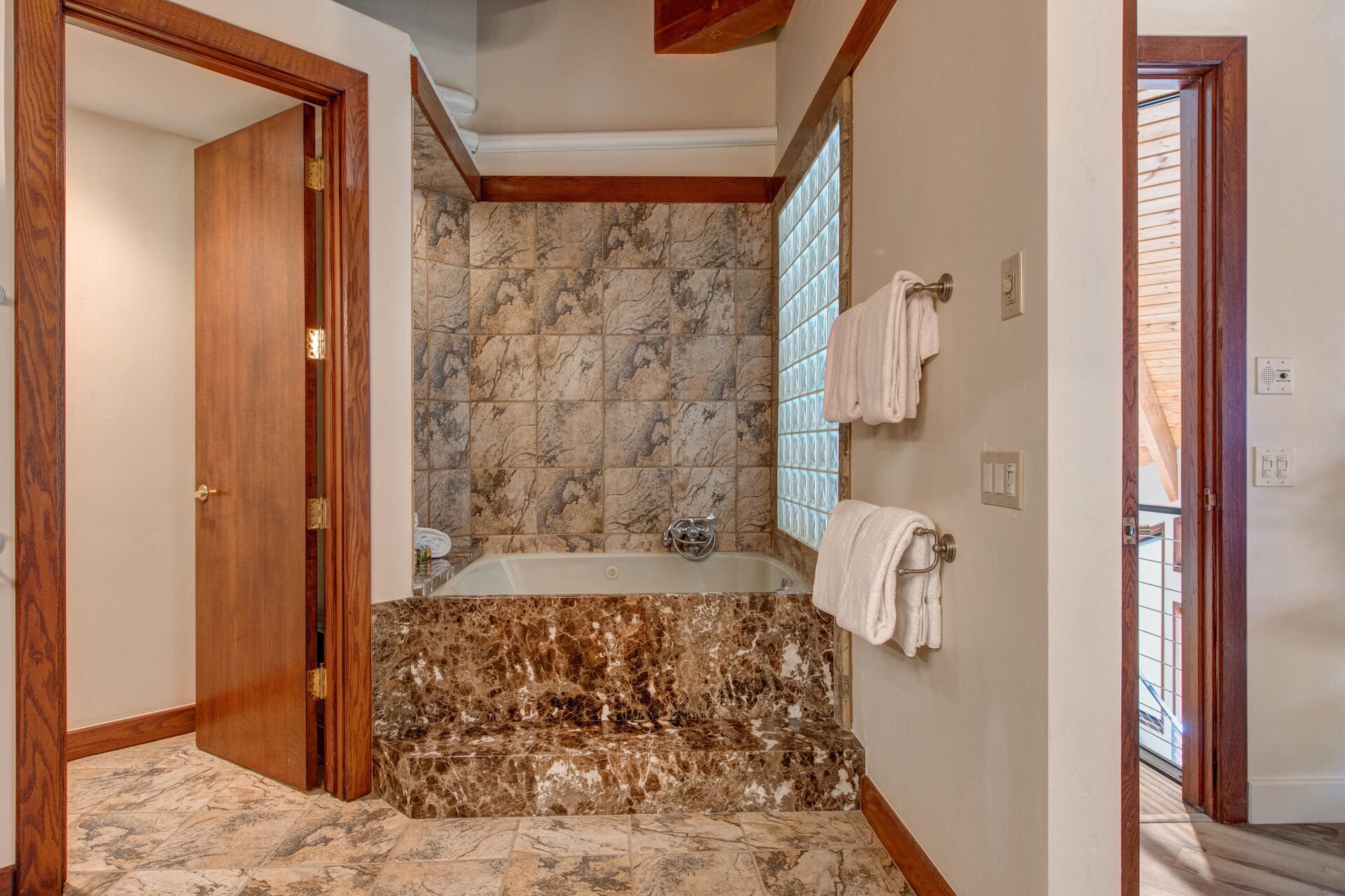 Grand Master Bathroom with dual vanities, beautiful stonework, tile & glass shower, and large jetted soaking tub