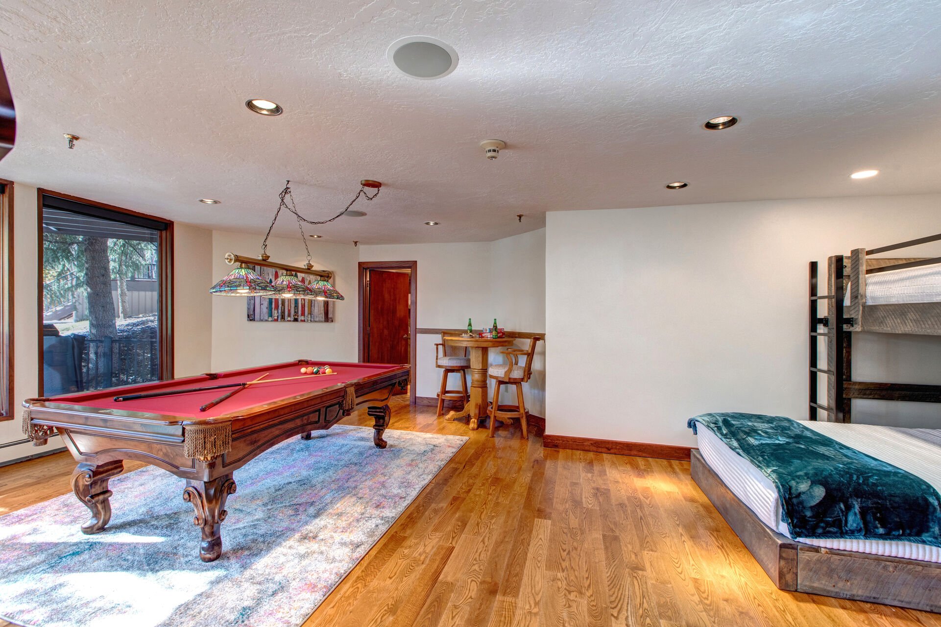 Lower Level Game/Sleeping Room with twin over twin and twin over queen bunks, high-top table for two, pool table, full bathroom, mudroom and private hot tub patio access