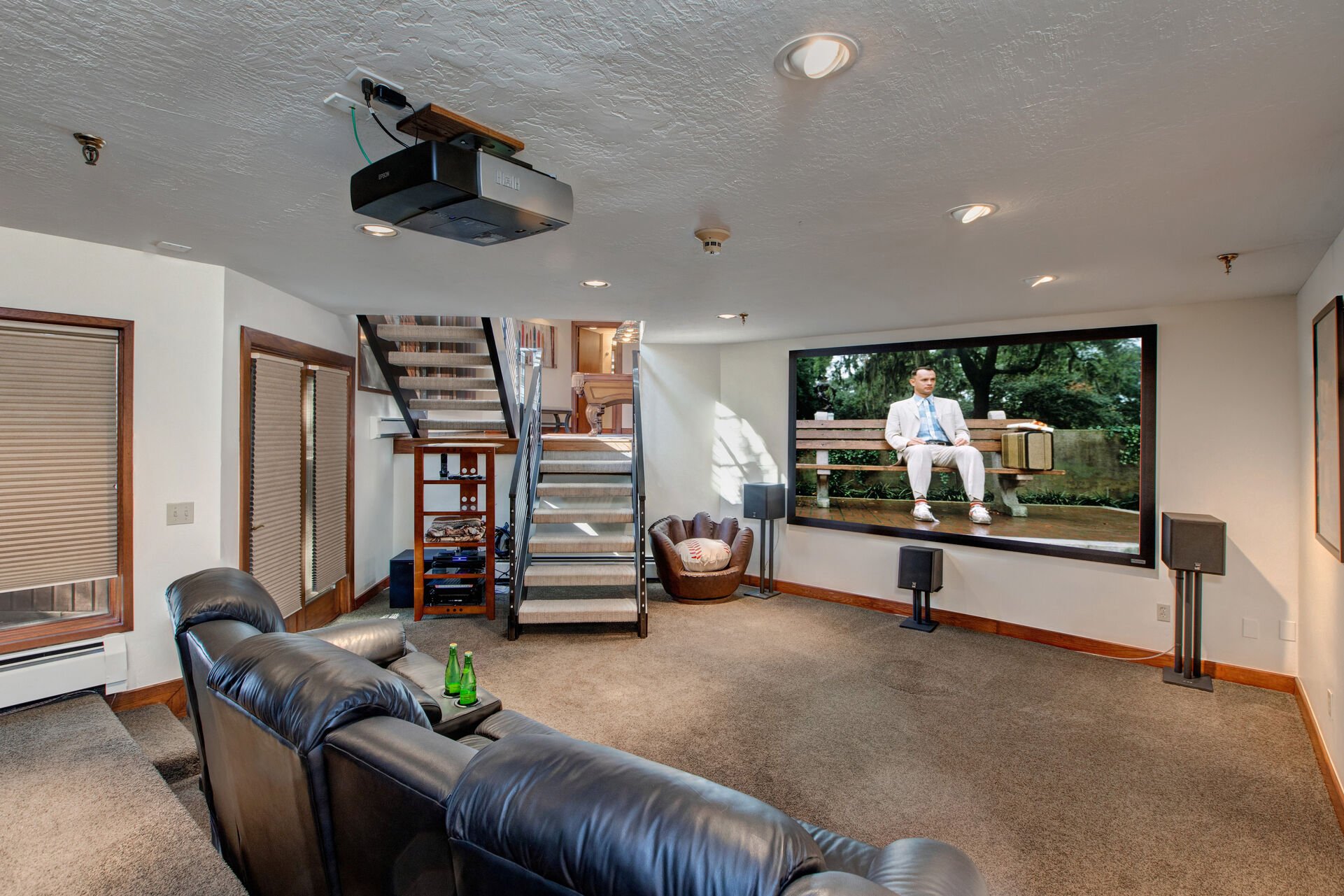 Basement Level Theatre Room with plush leather recliners for up to 7 guests, surround sound, and 150