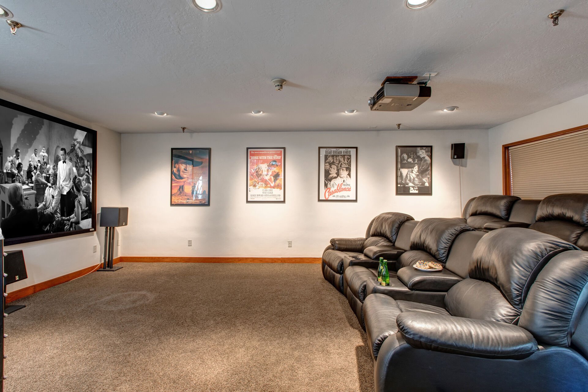 Basement Level Theatre Room with plush leather recliners for up to 7 guests, surround sound, and 150
