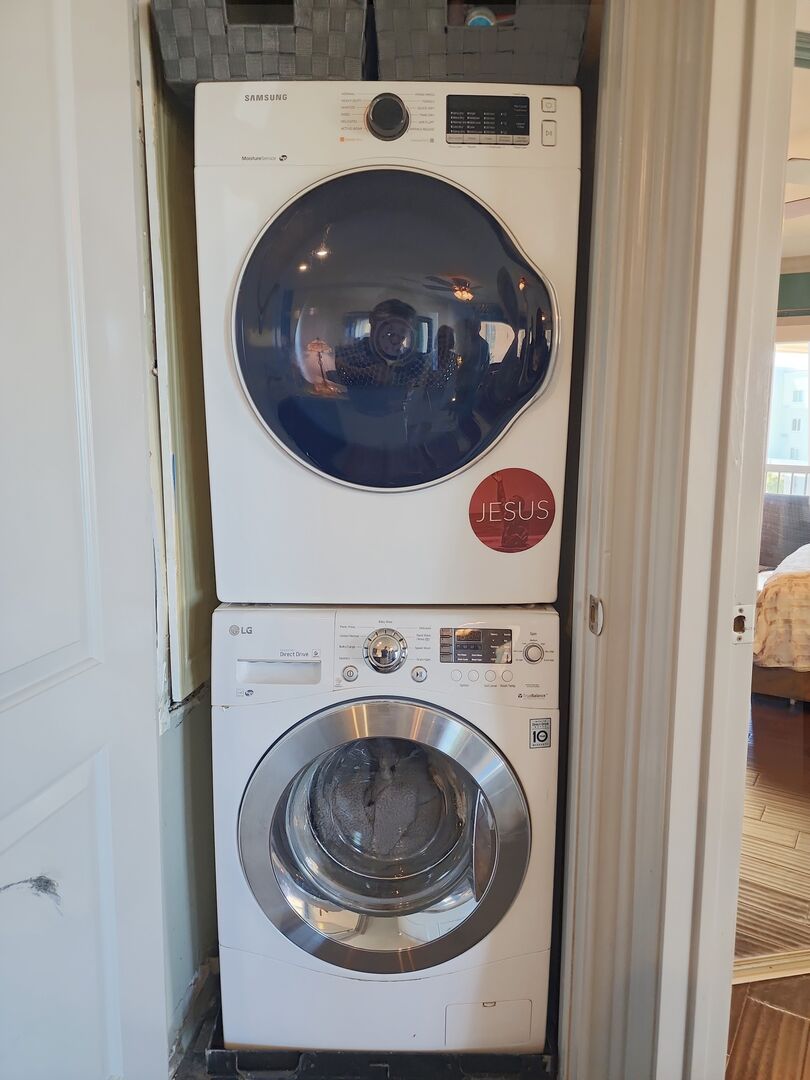 Stackable washer and dryer inside of the Pelican Place condo for guest convenience and satisfaction, starter set of laundry pods provided