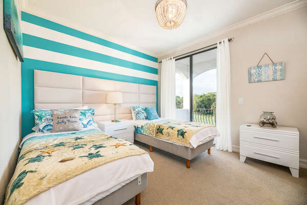 This coastal-themed bedroom on the third floor offers two twin beds with a shared balcony and bathroom