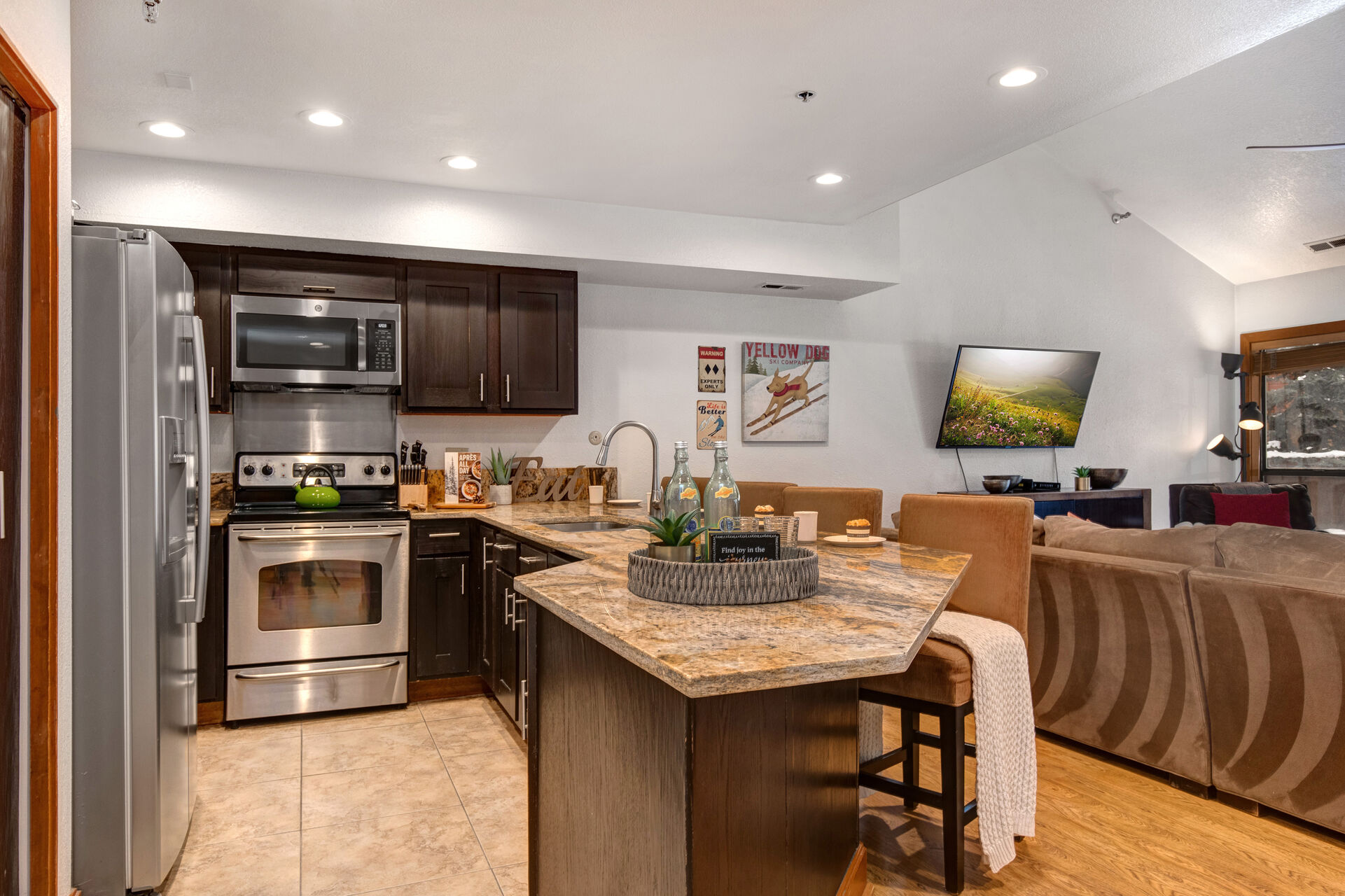 Fully Equipped Kitchen with gorgeous stone countertops, stainless steel appliances, and bar seating for four