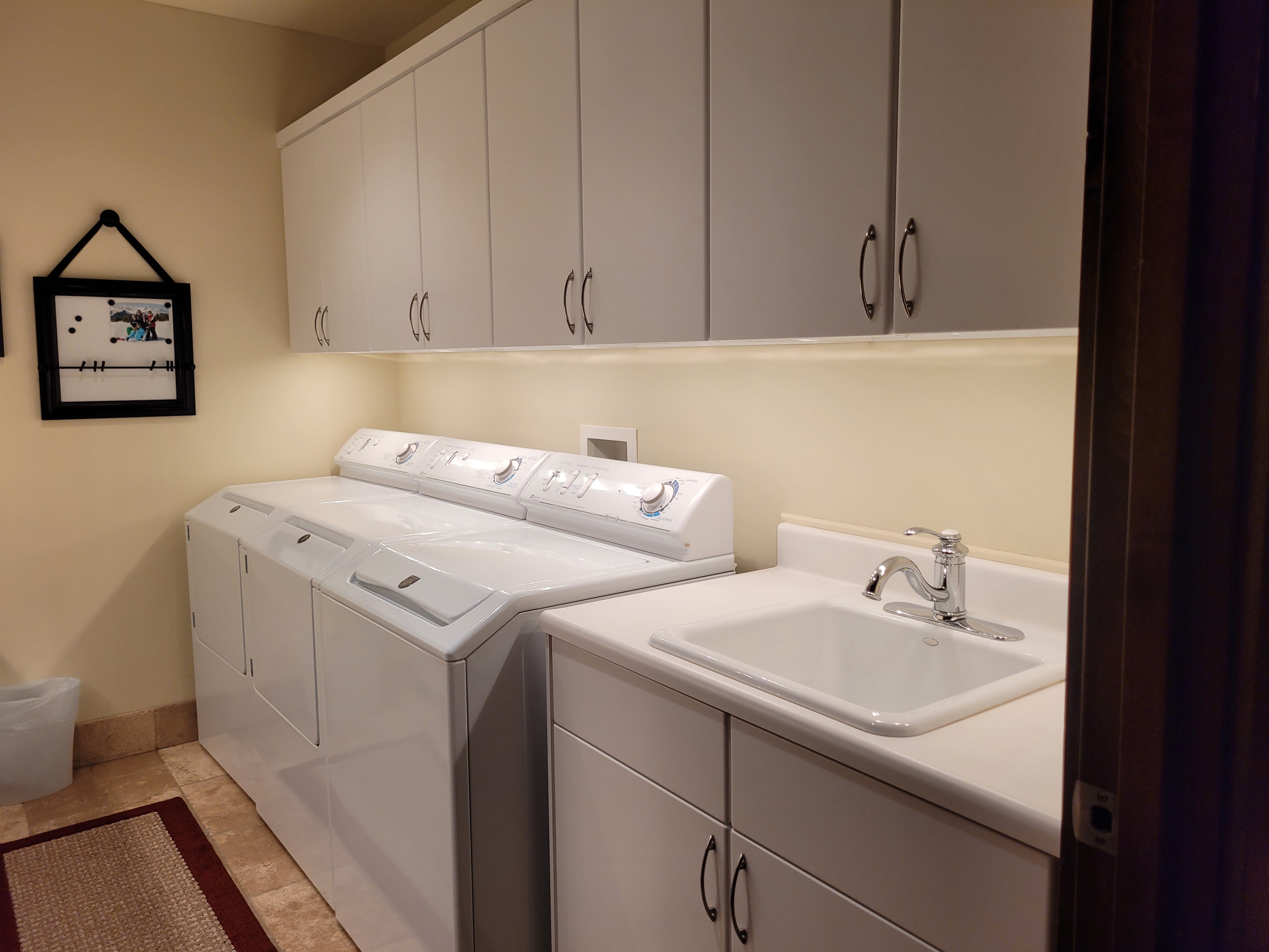 Laundry room with large washer and dryer and utility sink