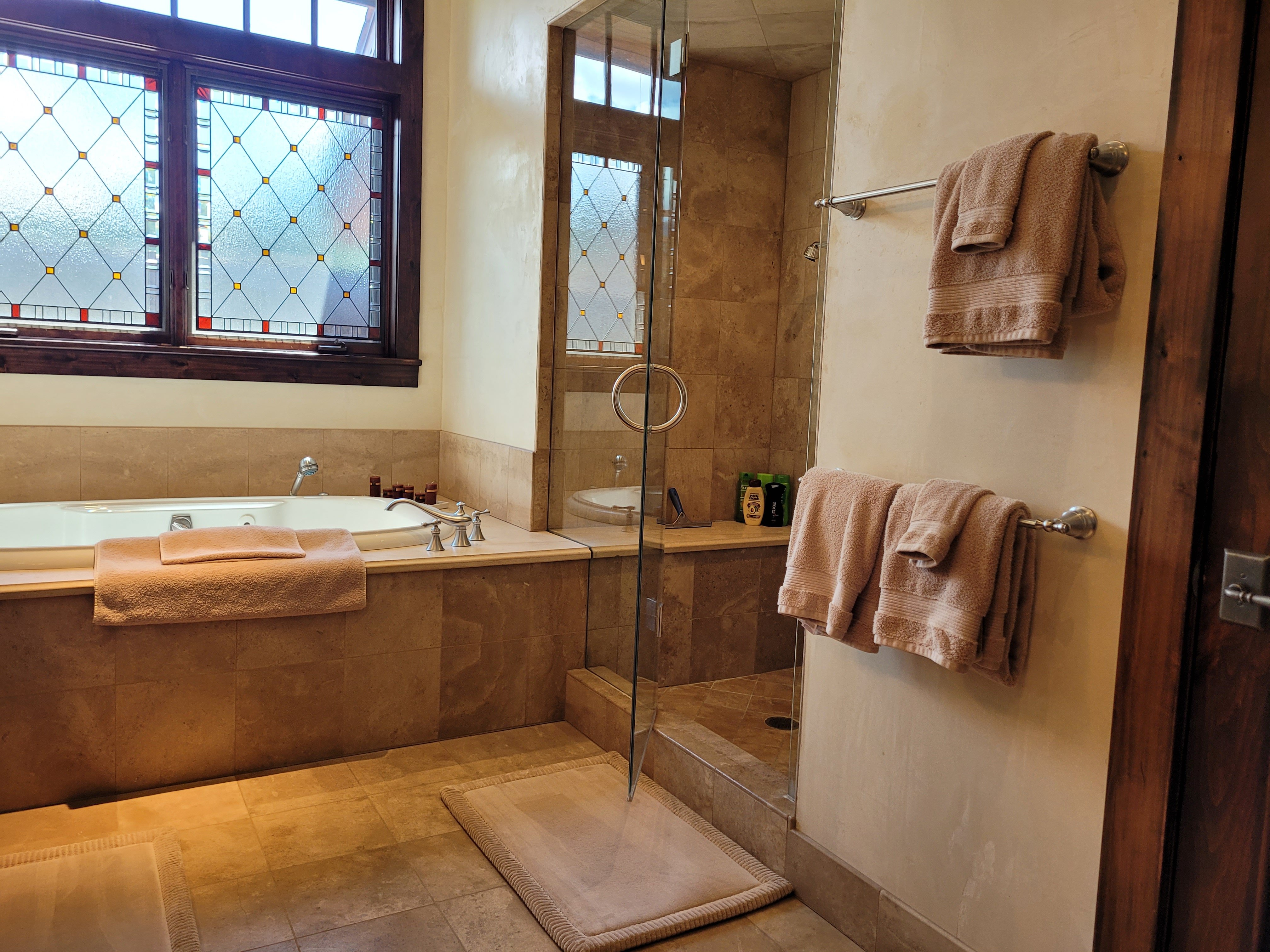 Luxury bathroom with brown tile and walk-in shower