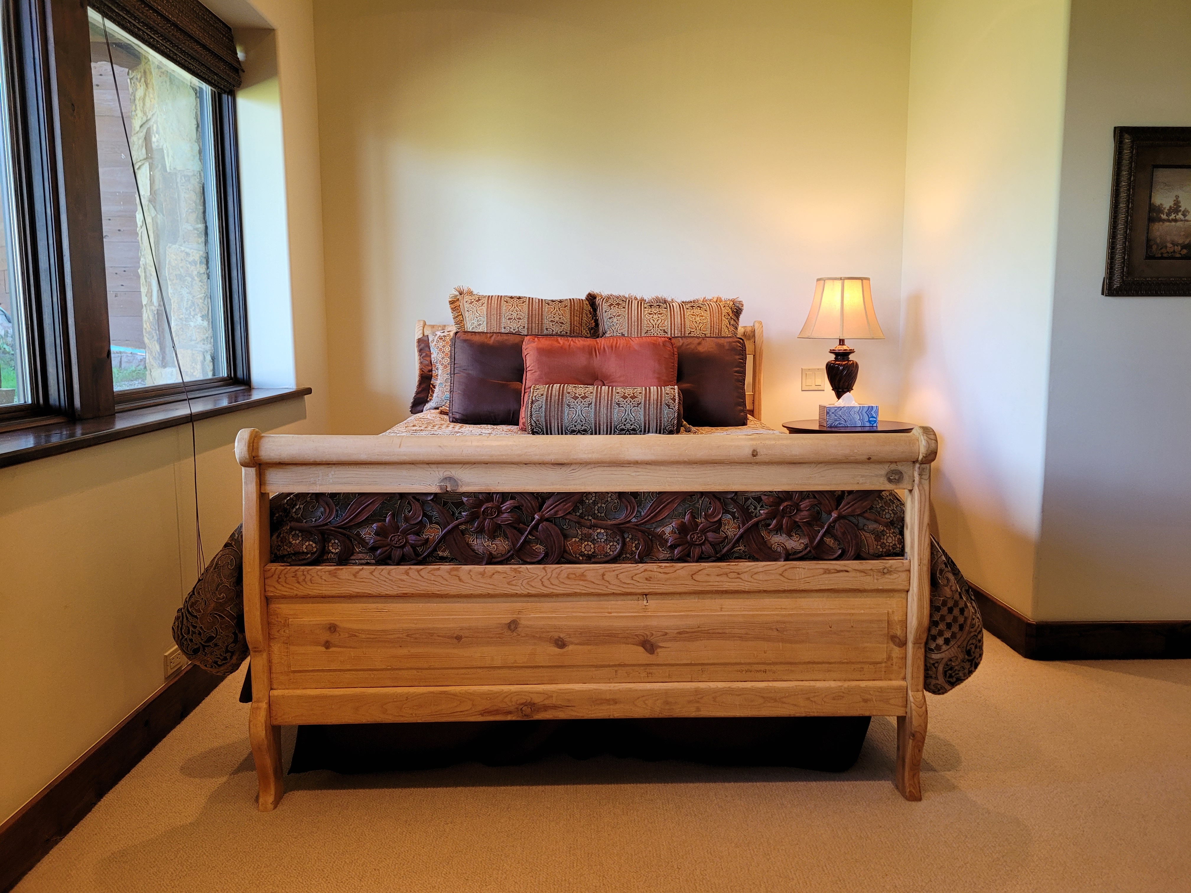 Bedroom with sleigh bed frame and decorative pillows