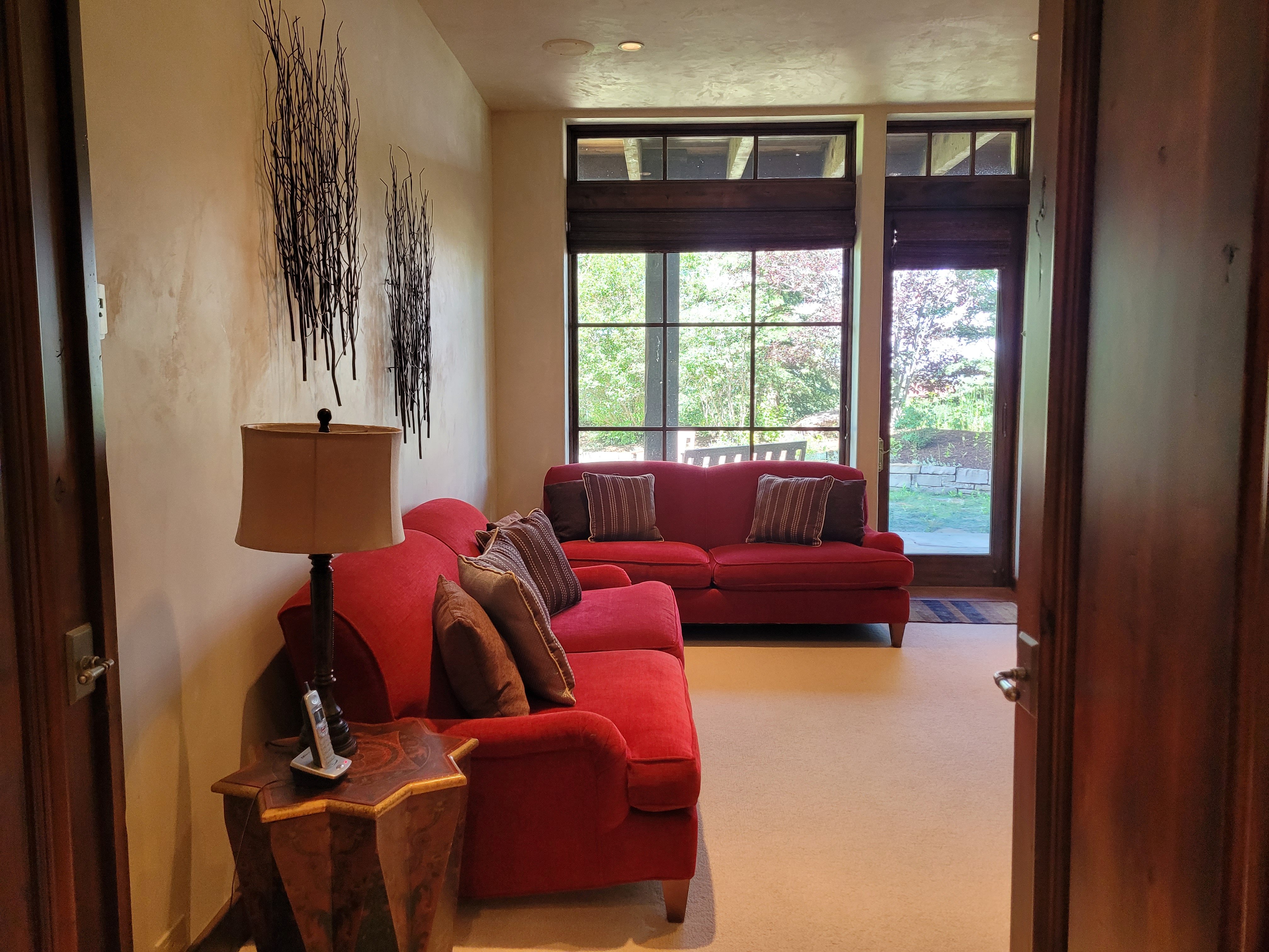Living room with red couches and large window