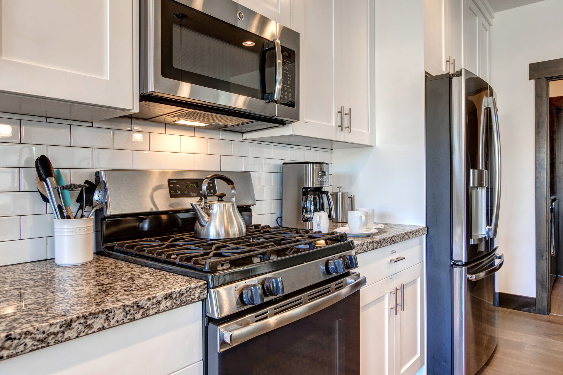 Fully Equipped Kitchen with gorgeous stone countertops, stainless steel appliances, ice maker, ample counter space, and oversized island with bar seating for four