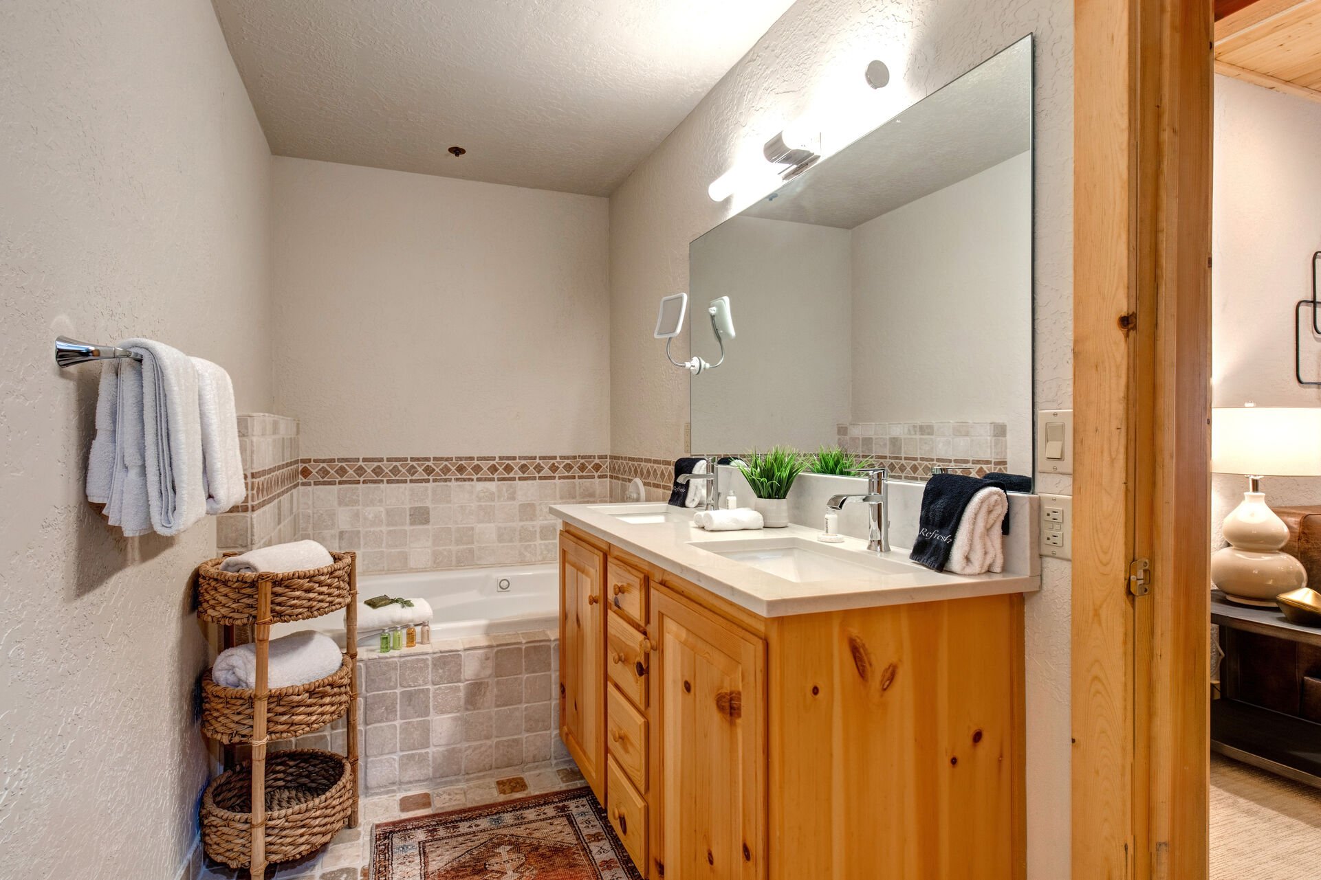 Master Bathroom with dual vanities, jetted soaking tub, and large tiled shower